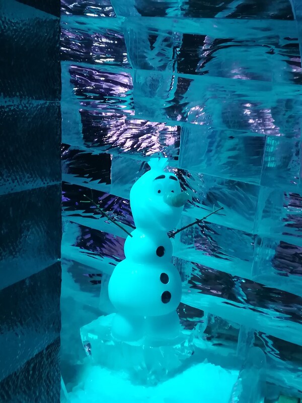Der aufgeweckte Schneemann Olaf guckt frech um die Ecke und grüßt ganz lieb.
